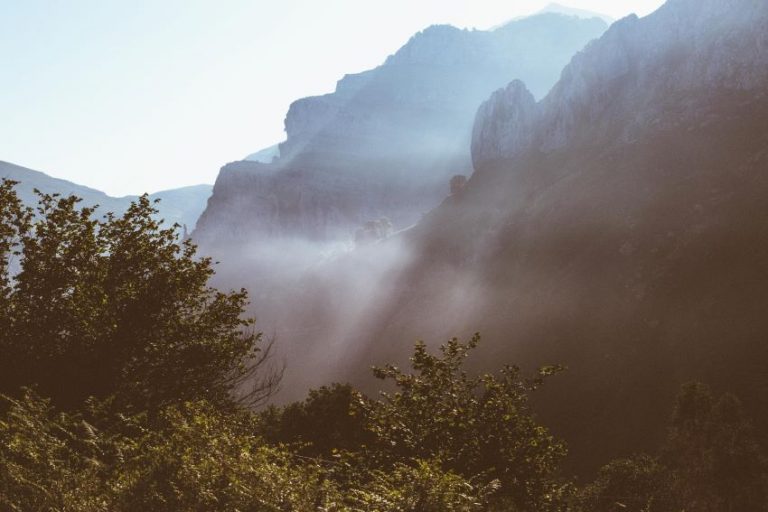 Rayos de sol entre la niebla iluminando las montañas de los Valles Pasiegos al amanecer.