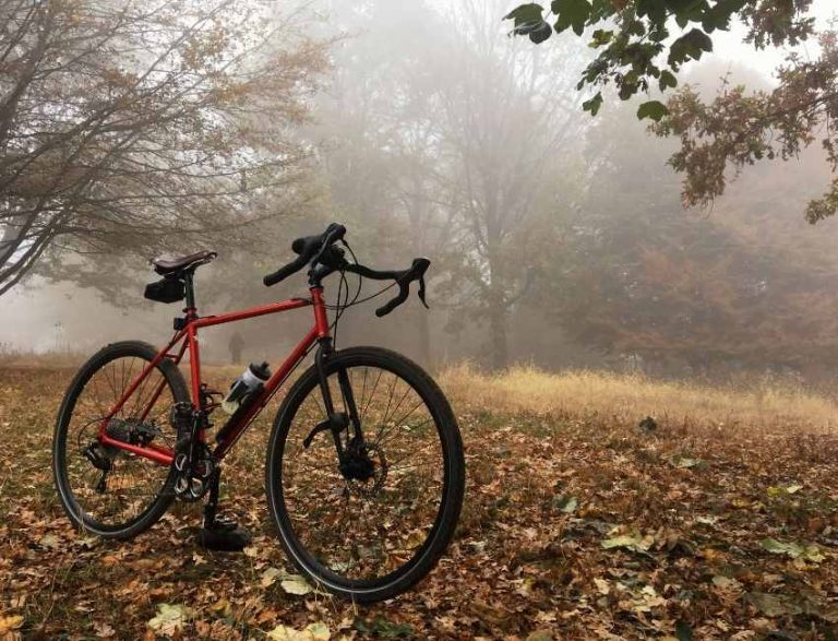 Bicicleta gravel en un bosque de otoño con niebla en los Valles Pasiegos, ideal para rutas de ciclismo en Cantabria.